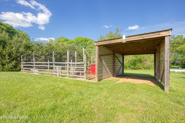 view of outbuilding with a detached carport and fence
