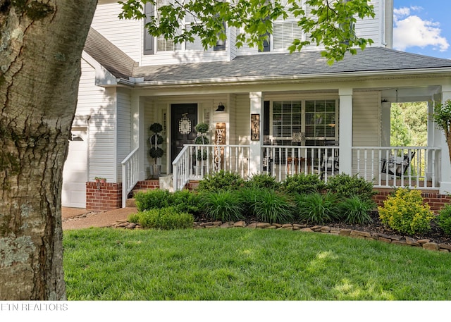 property entrance with a lawn, a shingled roof, and a porch