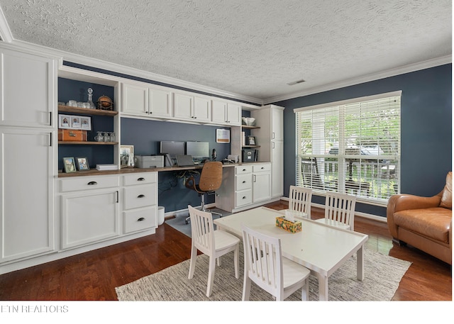 office area with built in study area, crown molding, and dark wood-style flooring