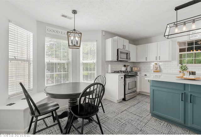 kitchen featuring stainless steel appliances, visible vents, decorative backsplash, and a wealth of natural light