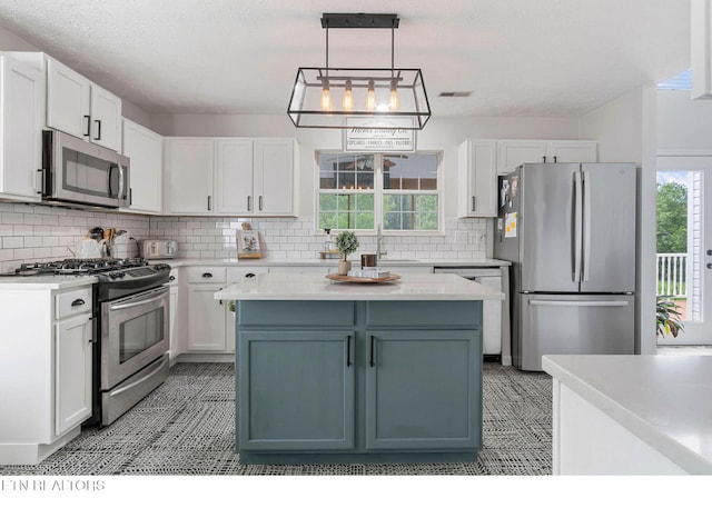 kitchen featuring light countertops, decorative backsplash, white cabinets, and stainless steel appliances