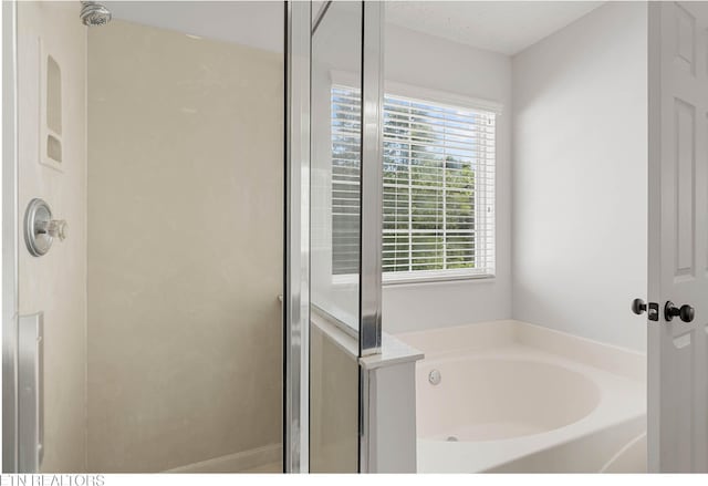 full bath featuring a garden tub and a shower stall