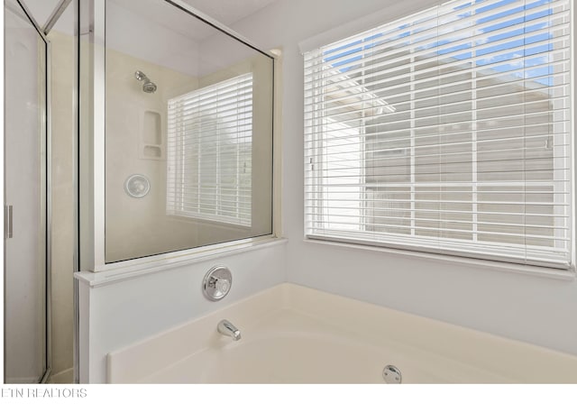 bathroom with a stall shower, a bath, and a healthy amount of sunlight