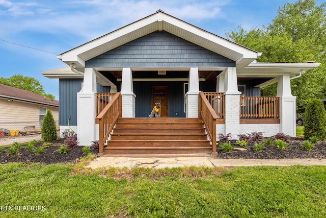 view of front of house featuring covered porch, board and batten siding, and a front lawn