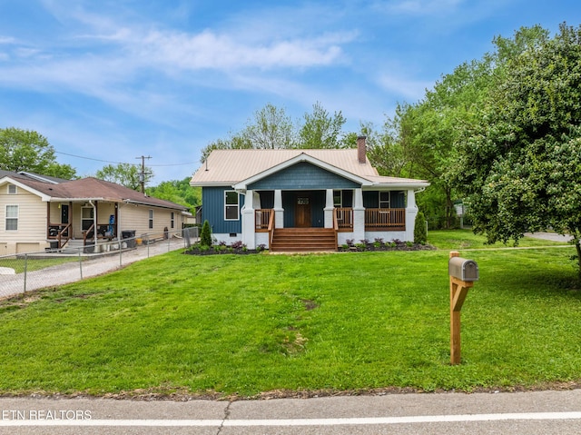bungalow-style home featuring fence, a front lawn, board and batten siding, a chimney, and covered porch
