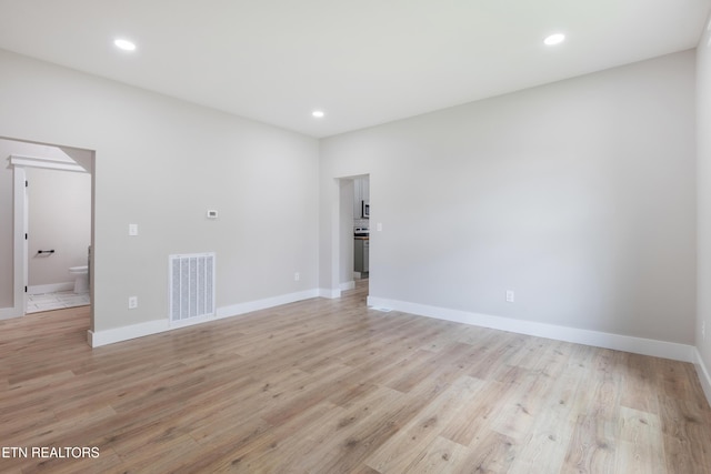spare room featuring light wood-style floors, baseboards, recessed lighting, and visible vents