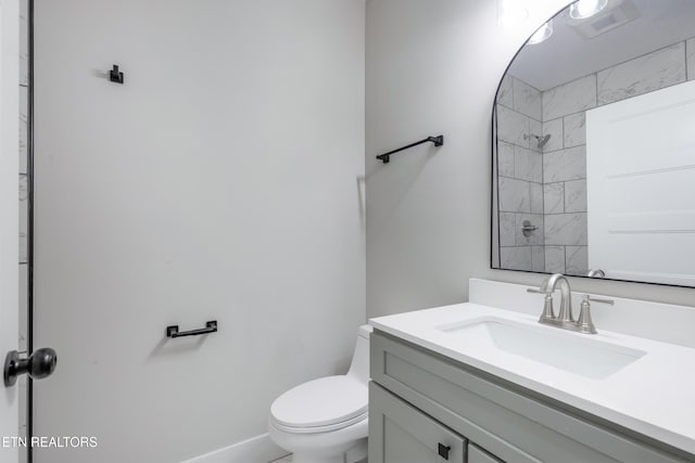 full bathroom with vanity, walk in shower, and toilet