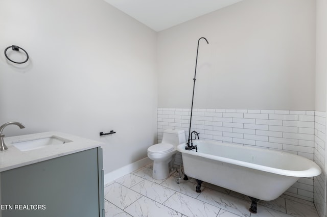 full bathroom with vanity, marble finish floor, toilet, and a soaking tub