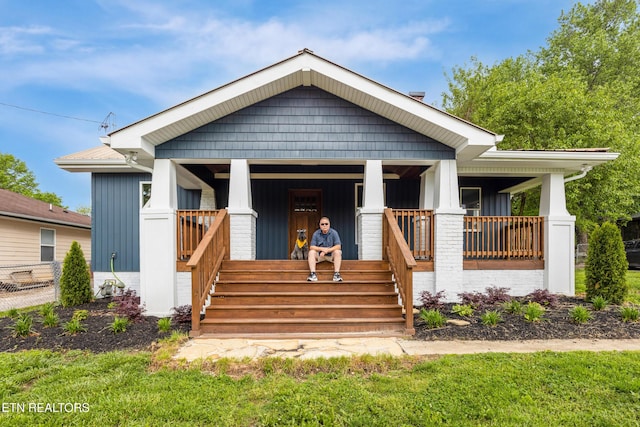 bungalow featuring covered porch and board and batten siding