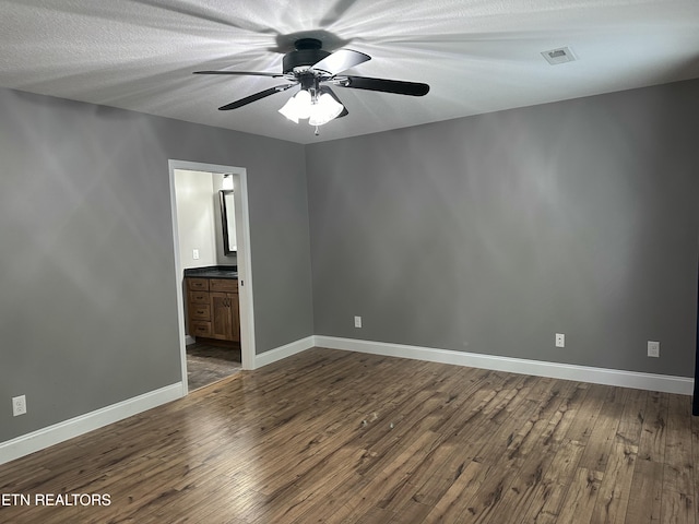 spare room with a ceiling fan, baseboards, and dark wood-style floors