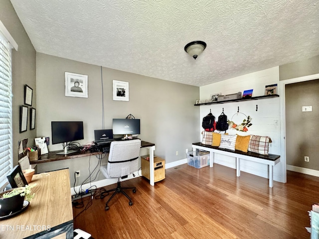 home office featuring baseboards, a textured ceiling, and wood finished floors