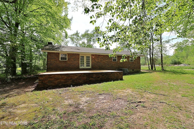 rear view of property with cooling unit, brick siding, french doors, and crawl space