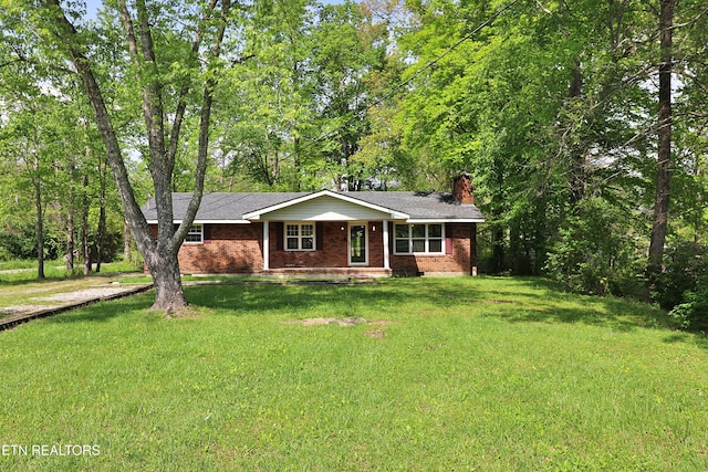 ranch-style house featuring covered porch, brick siding, a front lawn, and a chimney