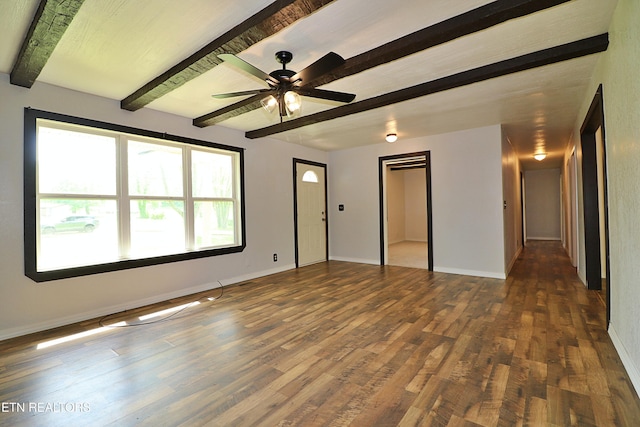 unfurnished room with beamed ceiling, a ceiling fan, baseboards, and wood finished floors