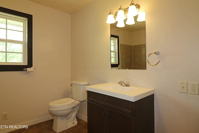 bathroom with toilet, baseboards, and vanity