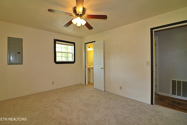 unfurnished bedroom with electric panel, carpet flooring, visible vents, and baseboards