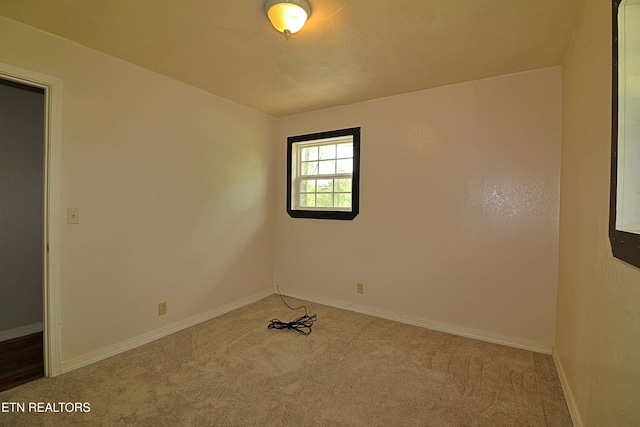empty room featuring baseboards and carpet