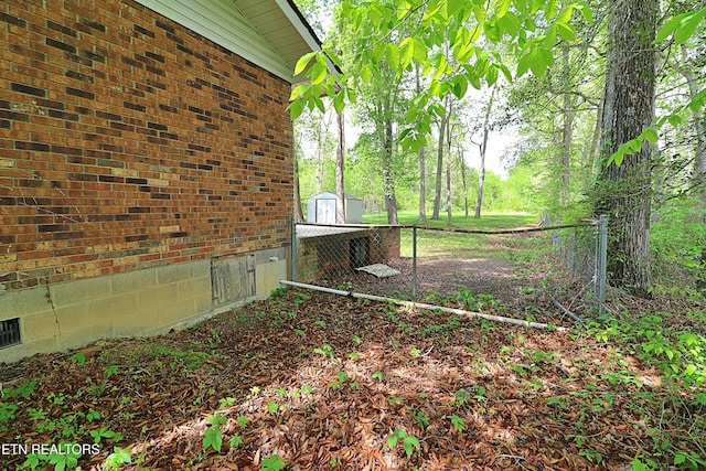 view of yard featuring fence, an outdoor structure, and a shed