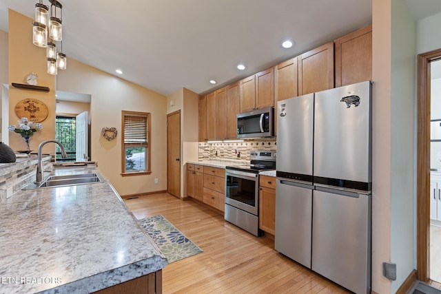 620 Hawk View Dr, Townsend, TN 37882 - kitchen featuring appliances with stainless steel finishes, a sink, backsplash, lofted ceiling, and light wood-style flooring
