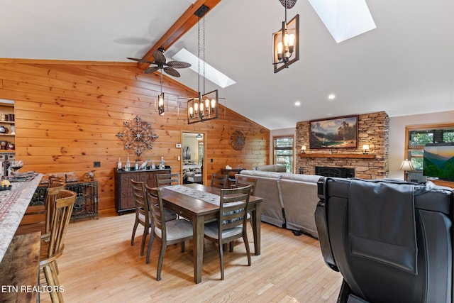 620 Hawk View Dr, Townsend, TN 37882 - dining space featuring a skylight, a ceiling fan, light wood finished floors, wood walls, and a stone fireplace