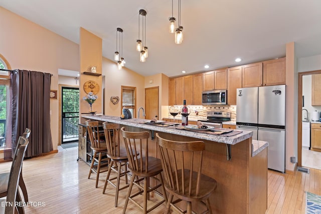 620 Hawk View Dr, Townsend, TN 37882 - kitchen featuring stainless steel appliances, vaulted ceiling, backsplash, light brown cabinetry, and light wood finished floors