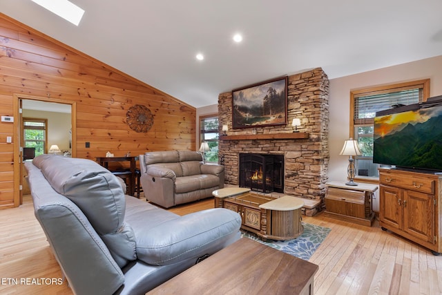 620 Hawk View Dr, Townsend, TN 37882 - living room with healthy amount of natural light, light wood-style flooring, a fireplace, vaulted ceiling, and wooden walls