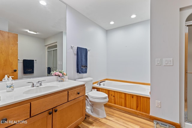 620 Hawk View Dr, Townsend, TN 37882 - bathroom with wood finished floors, toilet, a bath, vanity, and recessed lighting