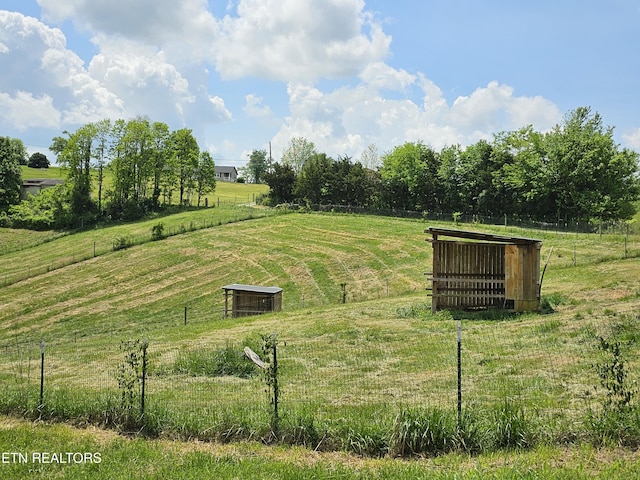 surrounding community with fence and a rural view