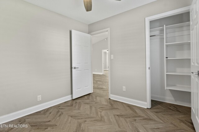 unfurnished bedroom with baseboards, ceiling fan, and a closet