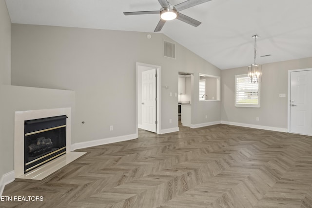 unfurnished living room with visible vents, baseboards, ceiling fan with notable chandelier, lofted ceiling, and a glass covered fireplace