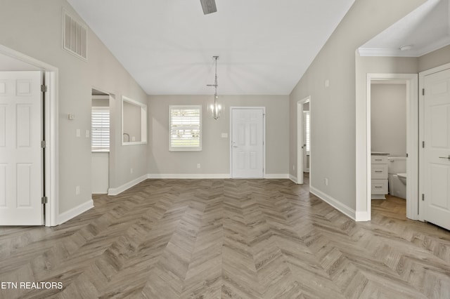 interior space with visible vents, baseboards, lofted ceiling, and an inviting chandelier