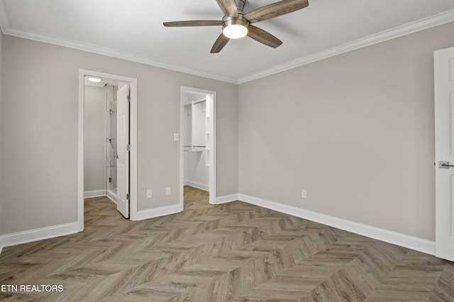 unfurnished bedroom with baseboards, ornamental molding, ceiling fan, and a spacious closet