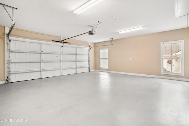 garage with baseboards and a garage door opener