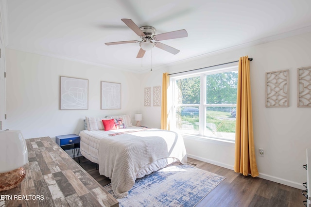 bedroom featuring baseboards, ornamental molding, ceiling fan, and wood finished floors