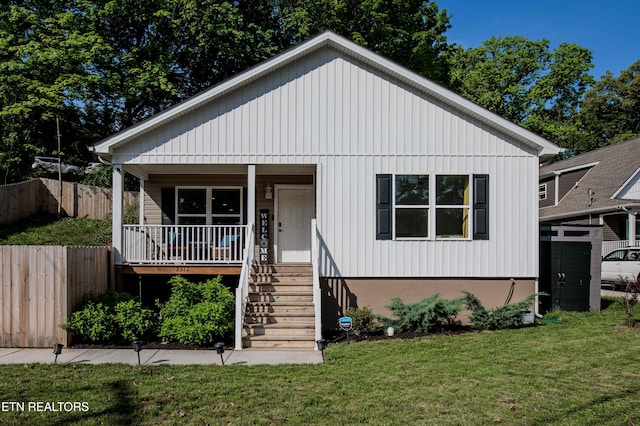 bungalow-style house featuring stairway, fence, covered porch, and a front yard