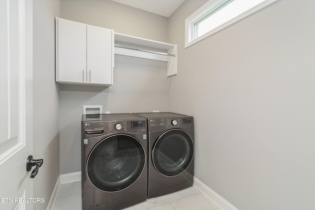 washroom with baseboards, marble finish floor, cabinet space, and washer and dryer