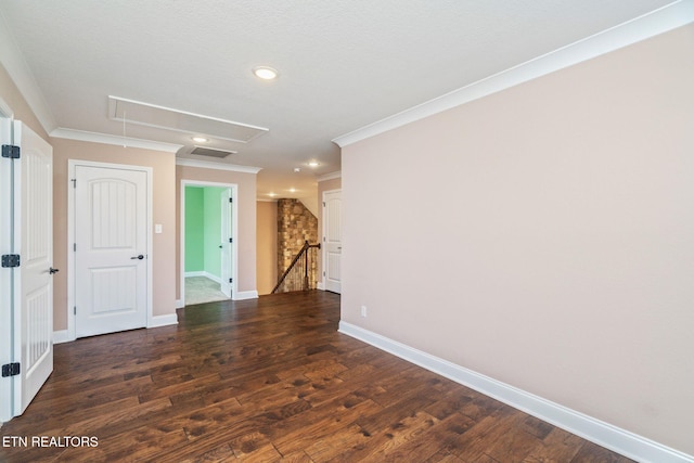 empty room featuring attic access, recessed lighting, baseboards, visible vents, and ornamental molding