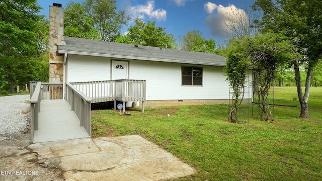 back of house with roof with shingles, a chimney, a yard, and crawl space