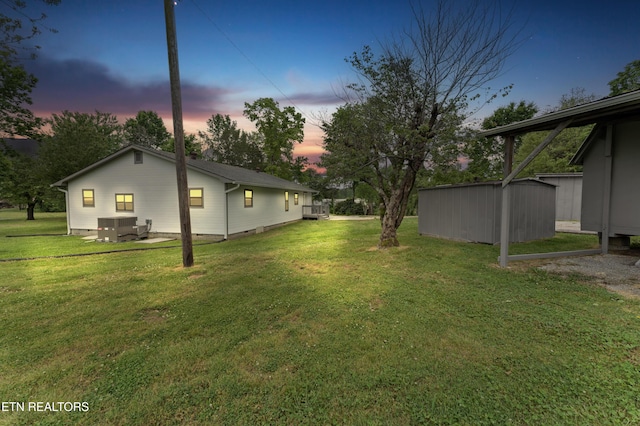 view of yard featuring an outbuilding, central AC unit, and a shed