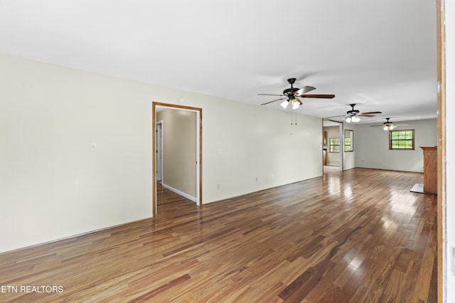 unfurnished living room featuring a ceiling fan and wood finished floors