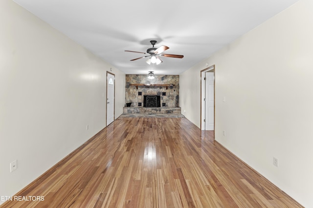 unfurnished living room featuring light wood-type flooring, ceiling fan, and a fireplace
