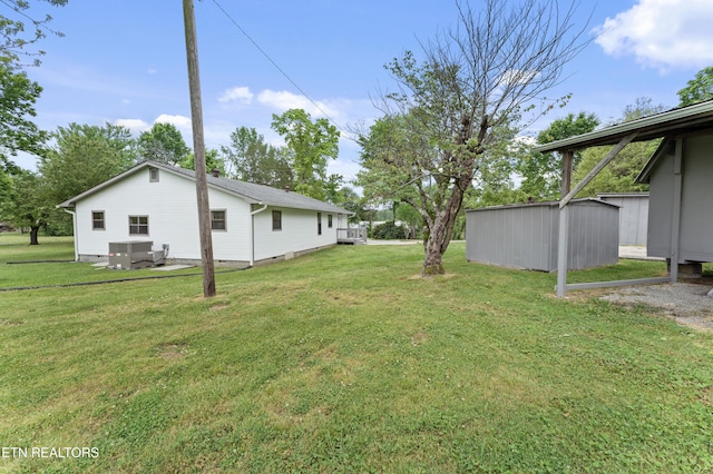 view of yard featuring central AC, an outbuilding, and a storage unit
