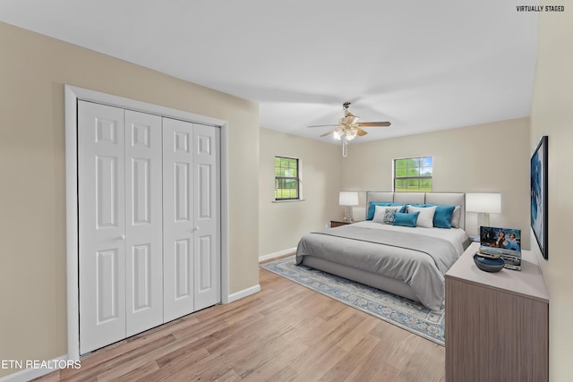 bedroom featuring a closet, light wood-type flooring, visible vents, a ceiling fan, and baseboards