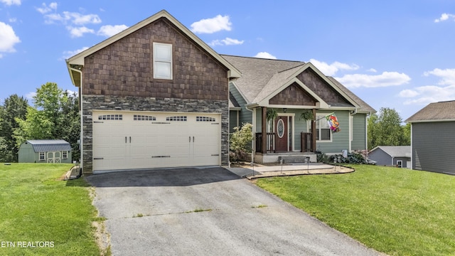 craftsman-style home with a front yard, a garage, stone siding, and aphalt driveway