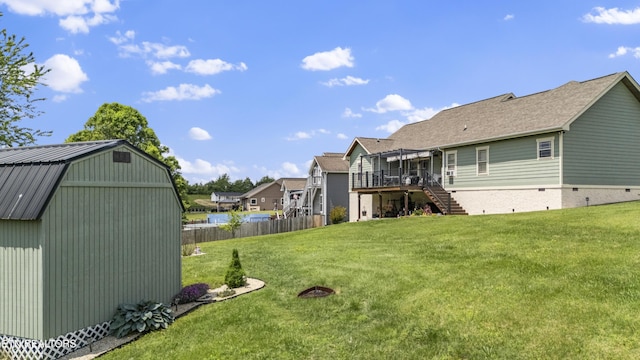 rear view of house featuring a lawn, fence, a wooden deck, and stairs