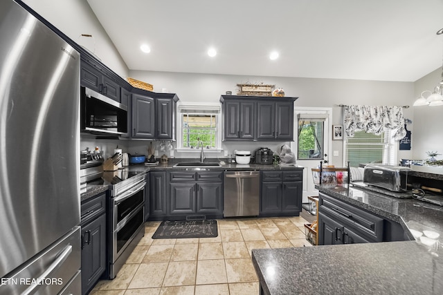kitchen with recessed lighting, a sink, appliances with stainless steel finishes, and a notable chandelier