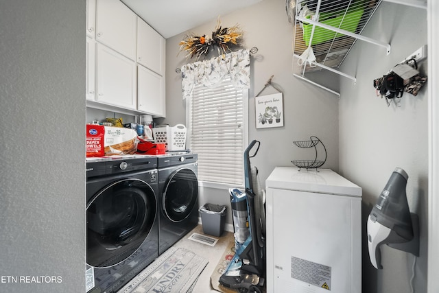 clothes washing area featuring cabinet space and washing machine and clothes dryer