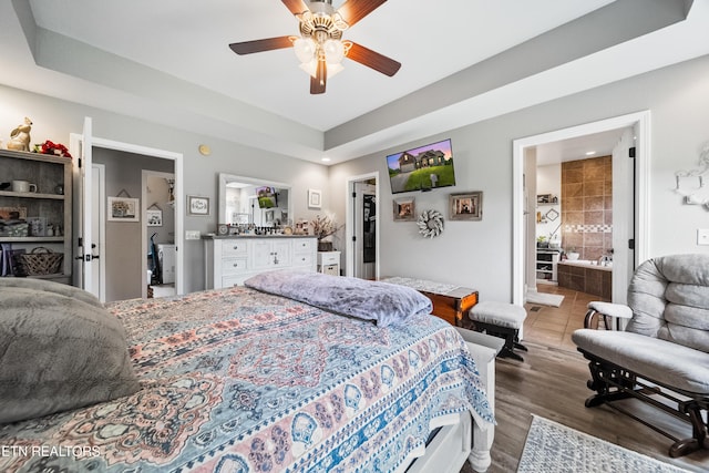bedroom featuring ensuite bathroom, recessed lighting, a walk in closet, and wood finished floors