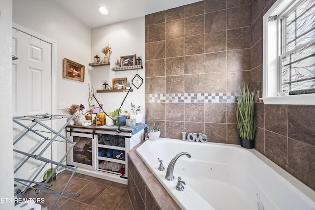 bathroom with tile patterned flooring and a tub with jets