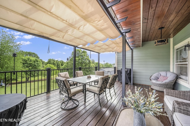 wooden deck with a lawn, outdoor dining space, and a grill